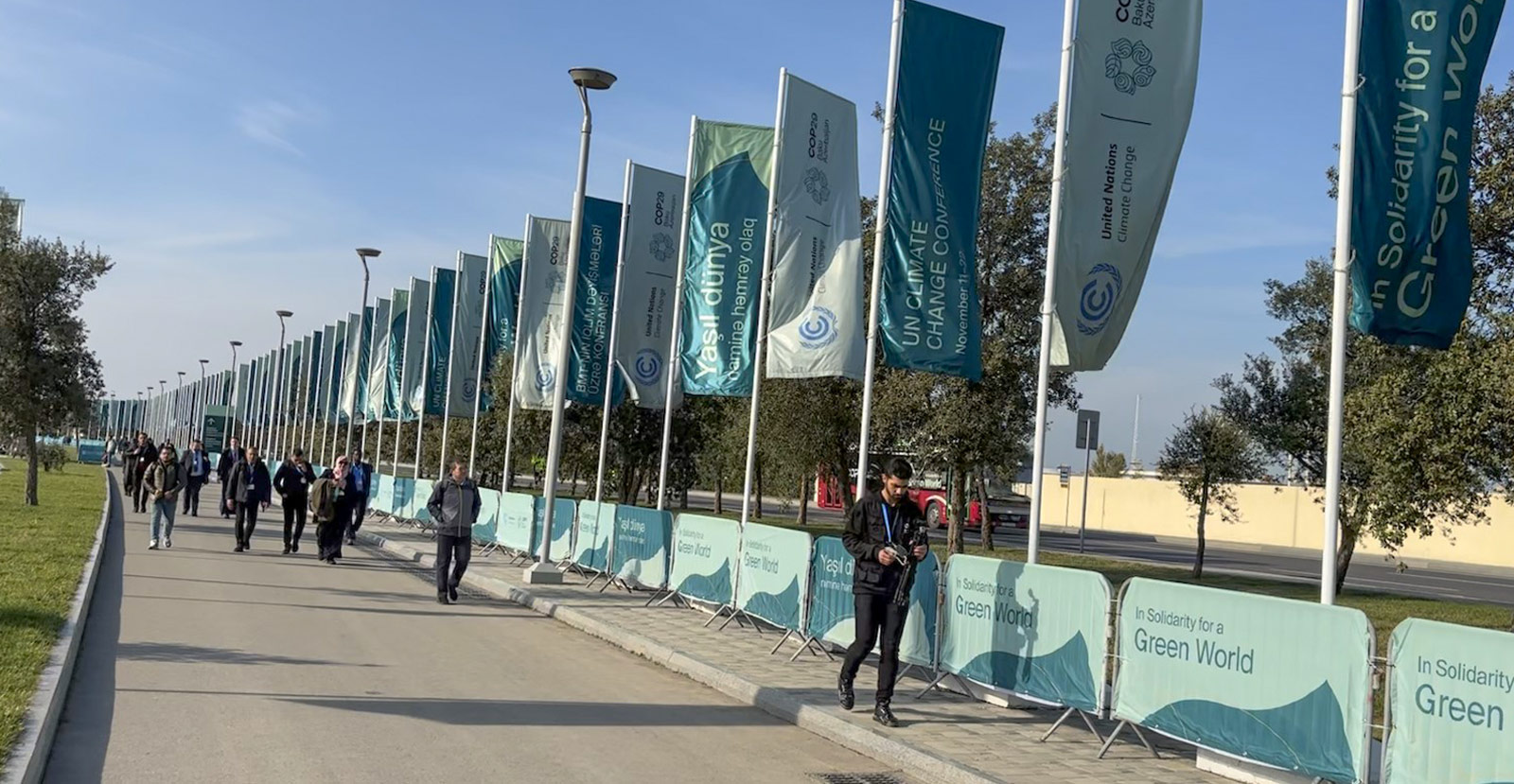 Participants at COP29 walk towards the venue