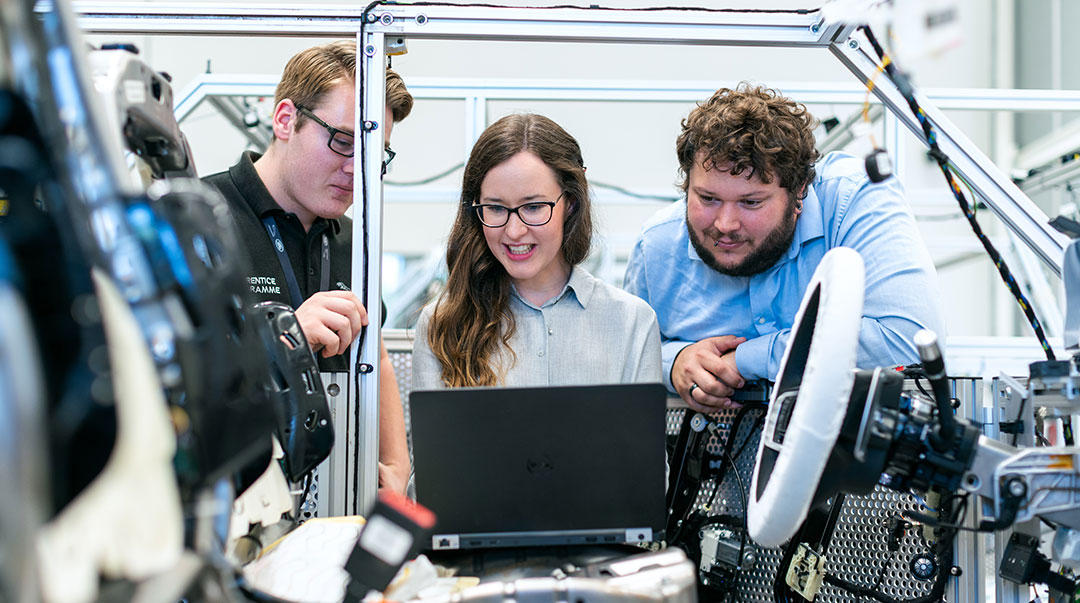 Three people looking at a laptop